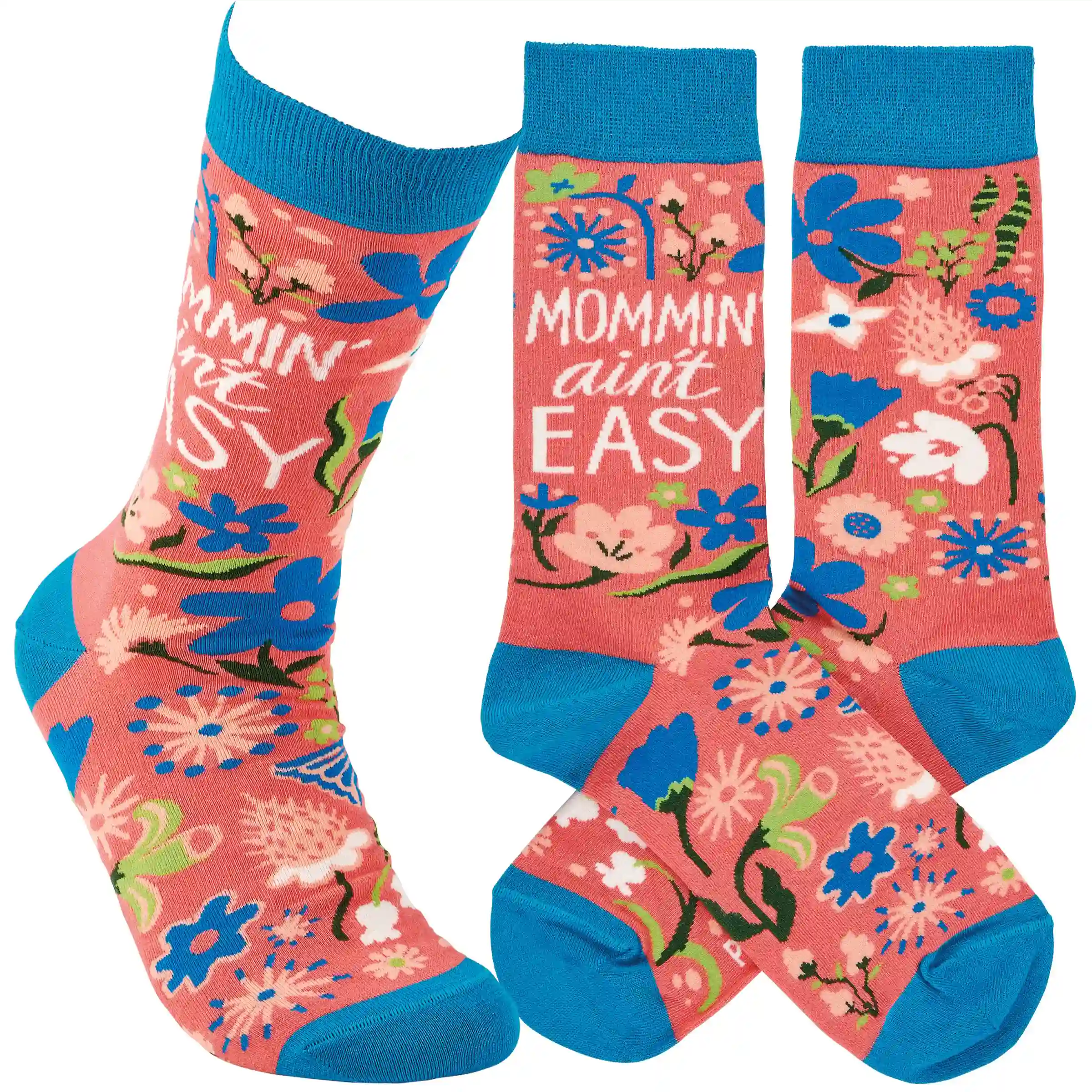 A pair of colorful woven socks from our Mother's Day Collection displaying unique hand illustrated designs of flowers with a fun mom-themed sentiment that reads "Mommin' Ain't Easy." Socks feature a one size fits most design made with cotton, nylon, and spandex. Our Mommin' Ain't Easy socks come with a header card and a clear plastic hanger for display. A fun Mother's Day gift and accessory perfect for everyday self-expression.